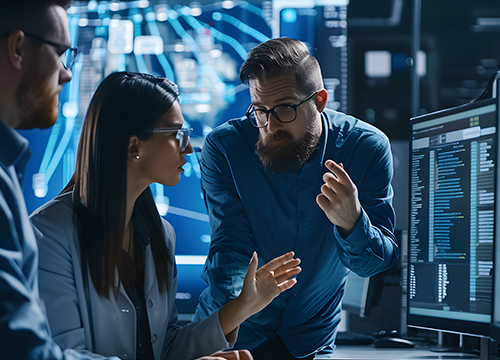Three people discussing at a workstation