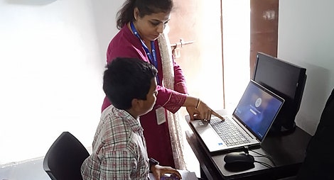 Teacher teaching student on laptop