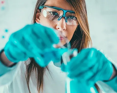 scientist mixing chemicals in flasks
