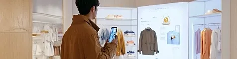A man checking clothes in a store with his mobile