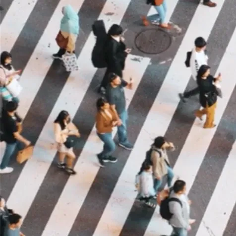 Various people crossing the street on a crosswalk