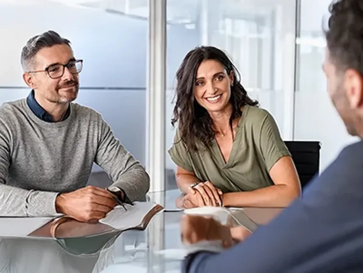 Three people discuss agentic AI in mortgage lending office.
