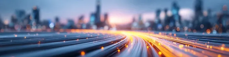 Glowing fiber‑optic lines curve through a futuristic blurred cityscape.