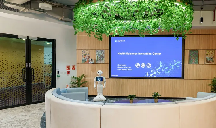 A office reception with a circular desk, complemented by green plants.