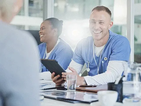 A couple of medical professionals smiling and talking to patients