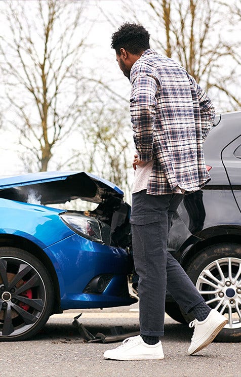 two crashed cars and someone looking at the damage