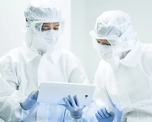 Two scientists looking at a tablet, held by one of them.
