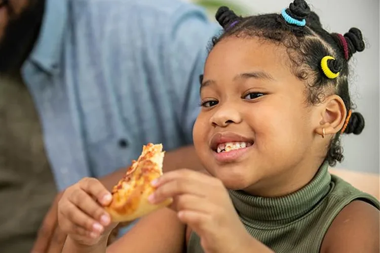 Face of little girl in front of another person who is standing