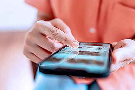A closeup view of someone scrolling on a mobile phone