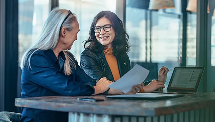 Two women sitting and smiling at eachother