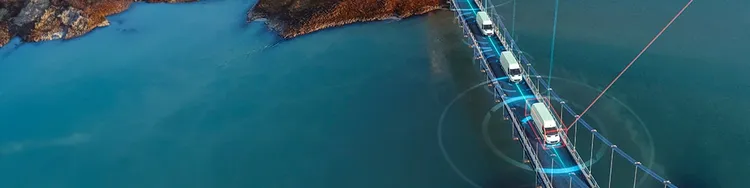 Vehicles crossing a bridge over sea, with digital network connectivity and communication between the vehicles.