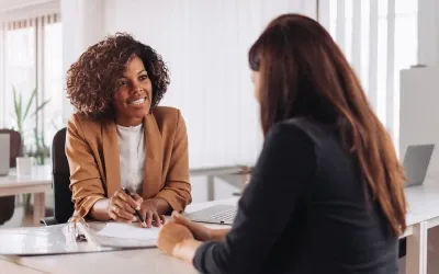 An insurance agent sitting across a table consulting another woman