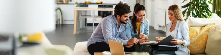 Three colleagues having a discussiong while they look into a document folder