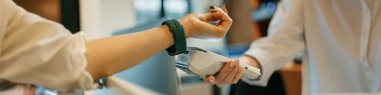 A person scanning the smatchwatch of a woman using a device