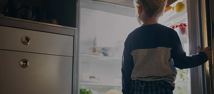 boy looking in fridge