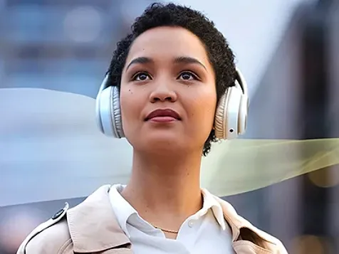 Woman on her headphone looking straight ahead.