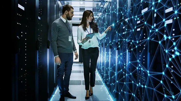 A male and female colleague looking at computerized connecting data center points.