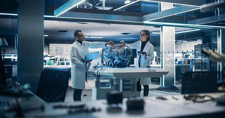 A male and female colleague working on aerospace object while having a discussion.