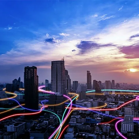 Colorful fiber optic cables running through city skyline