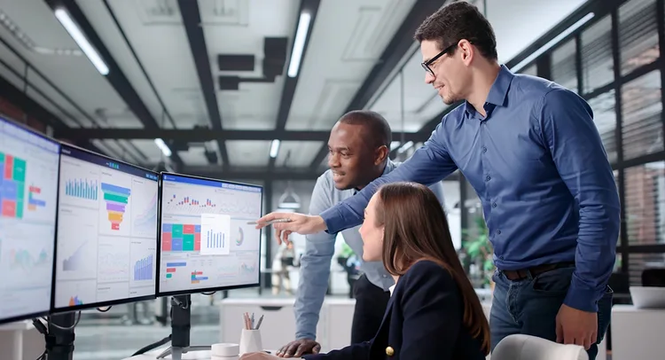 Three people discussing by looking at a computer screen