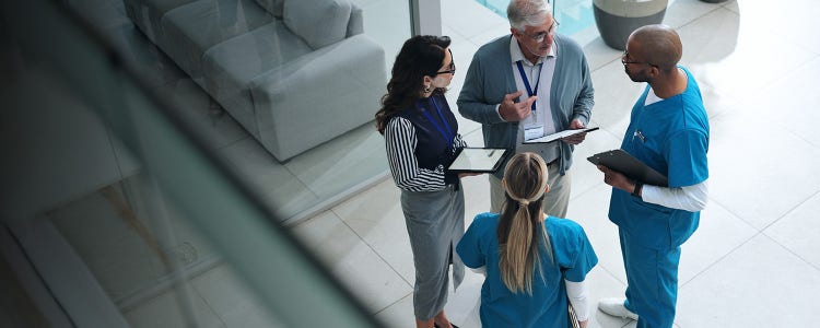 Four professionals standing in a circle and discussing