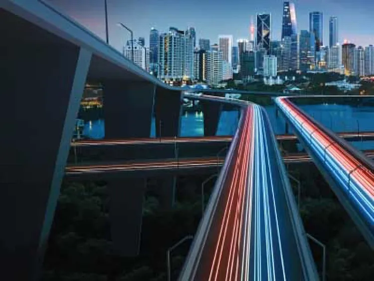 Fast moving traffic on road and overpasses with a view of the ctiy with highrises in the background