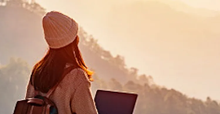 A woman with a backpack and a laptop outdoors