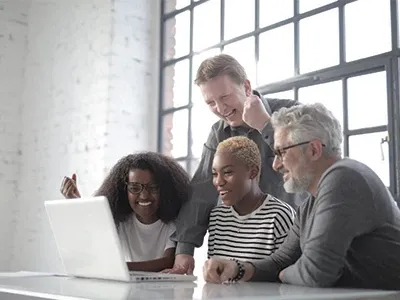 team looking in a laptop