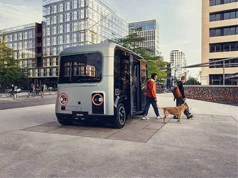 Two people leaving a smart bus with a dog.