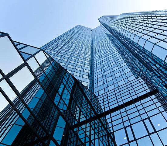 A tall banking building featuring sleek glass windows reflecting the sky
