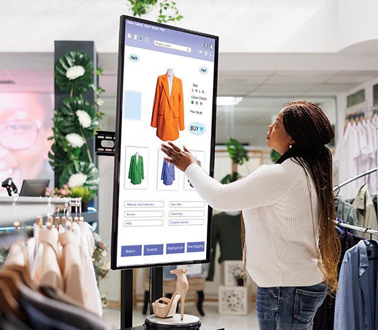 A woman interacts with a digital clothing display, highlighting retail options in the consumer goods and travel hospitality sectors